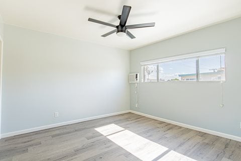 an empty room with a ceiling fan and a window