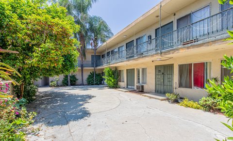the courtyard of an apartment building with a driveway and a balcony