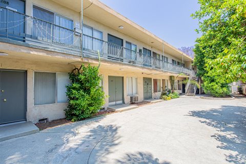 the courtyard of an apartment building with balconies and a driveway