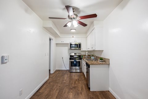 A kitchen with a fan on the ceiling.