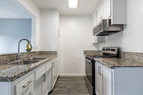 A kitchen with granite countertops and stainless steel appliances.