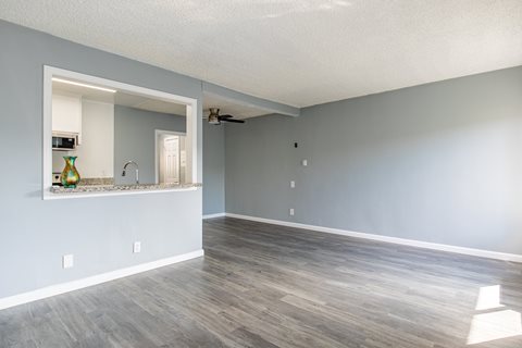 A room with a grey wall and a wooden floor.