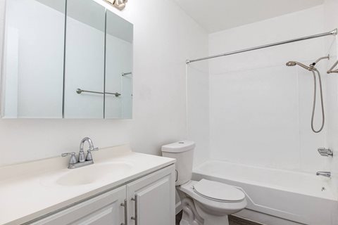 A white bathroom with a toilet, sink, and bathtub.