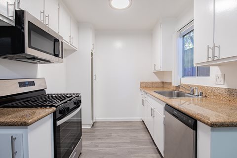 A kitchen with white cabinets and a black stove top oven.