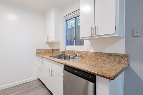 A kitchen with a granite countertop and stainless steel appliances.