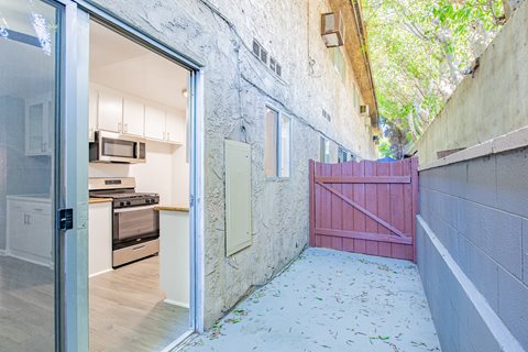 A kitchen with a red gate is visible through an open door.