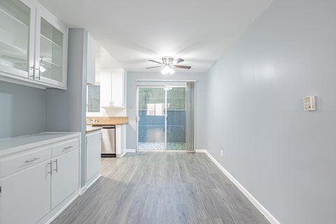A long, narrow hallway with a ceiling fan and a door leading to a balcony.