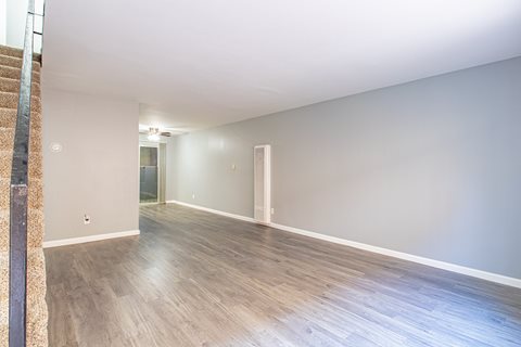 A room with wooden flooring and white walls.