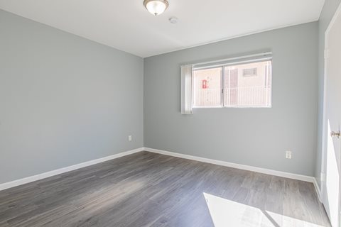 A room with a window and wooden flooring.