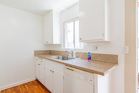 A kitchen with white cabinets and a granite countertop.