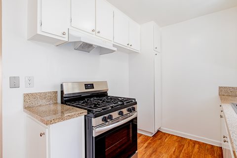 A kitchen with a stove and cabinets.