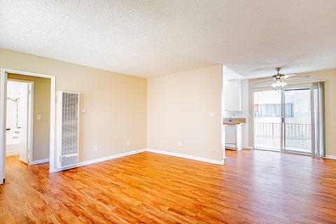 A room with wooden floors and a ceiling fan.