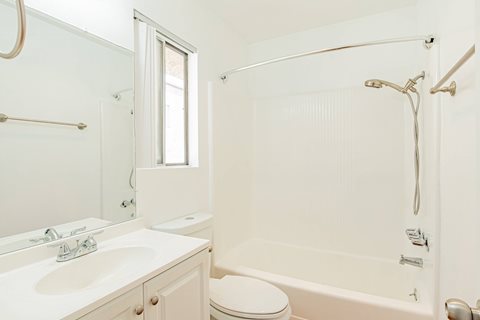 A white bathroom with a toilet, sink, and bathtub.