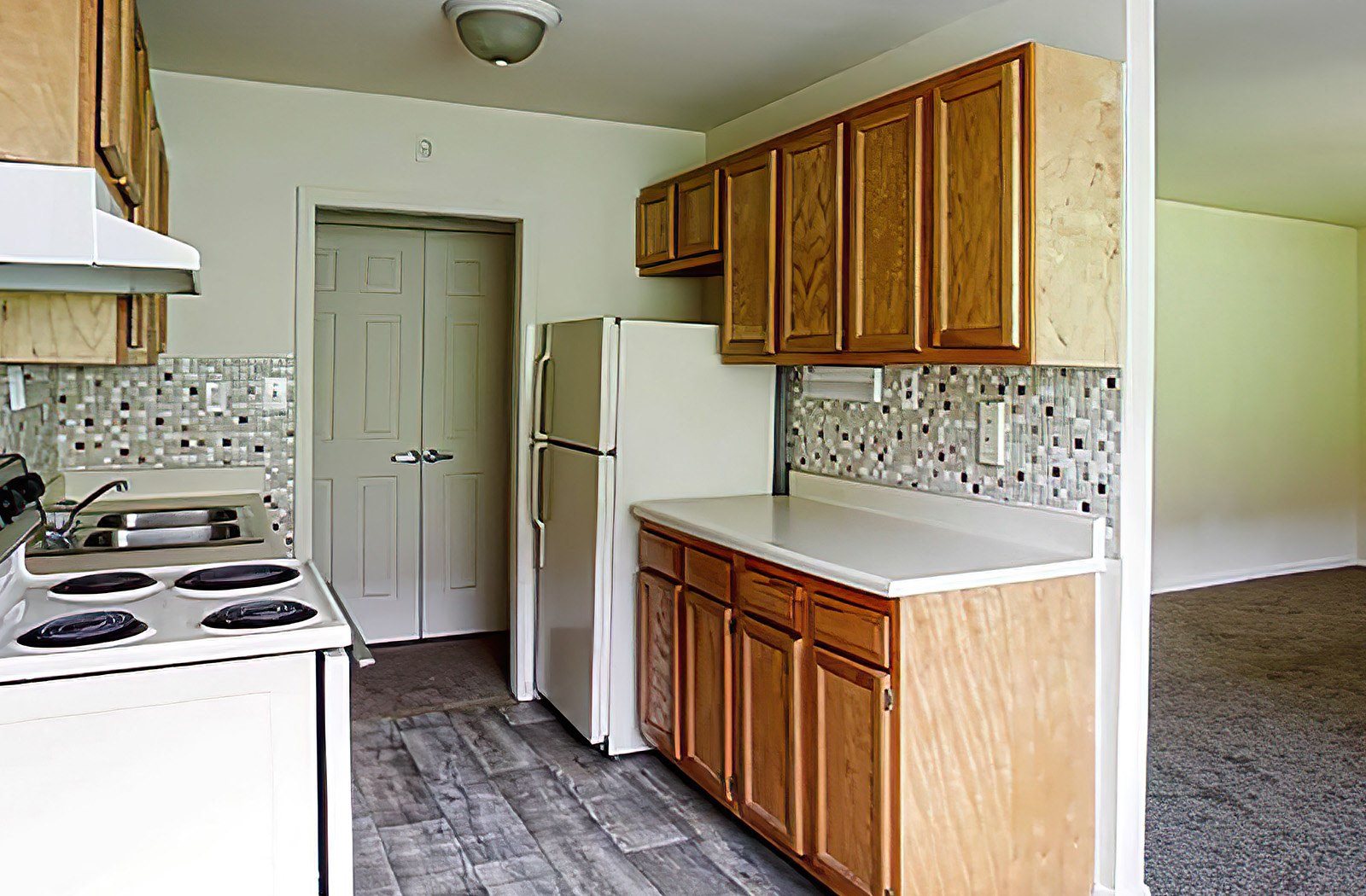 a kitchen with white appliances and wooden cabinets