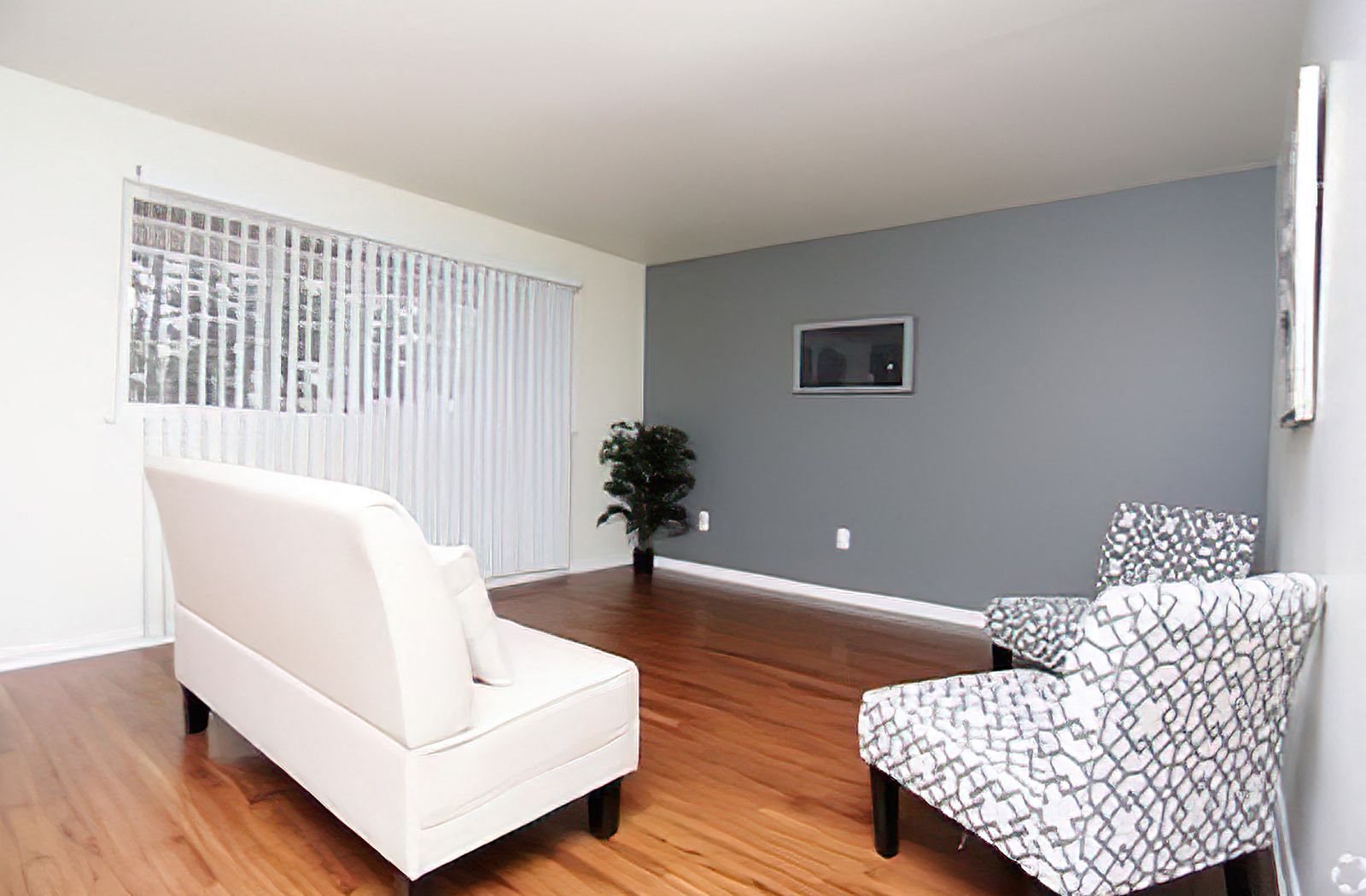 a living room with a white couch and two chairs
