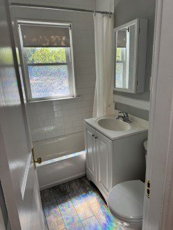 A white bathroom with a toilet, sink, and shower.