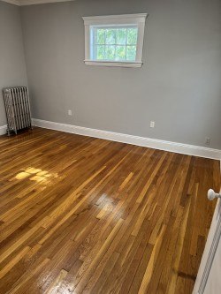 A room with wooden flooring and a window.