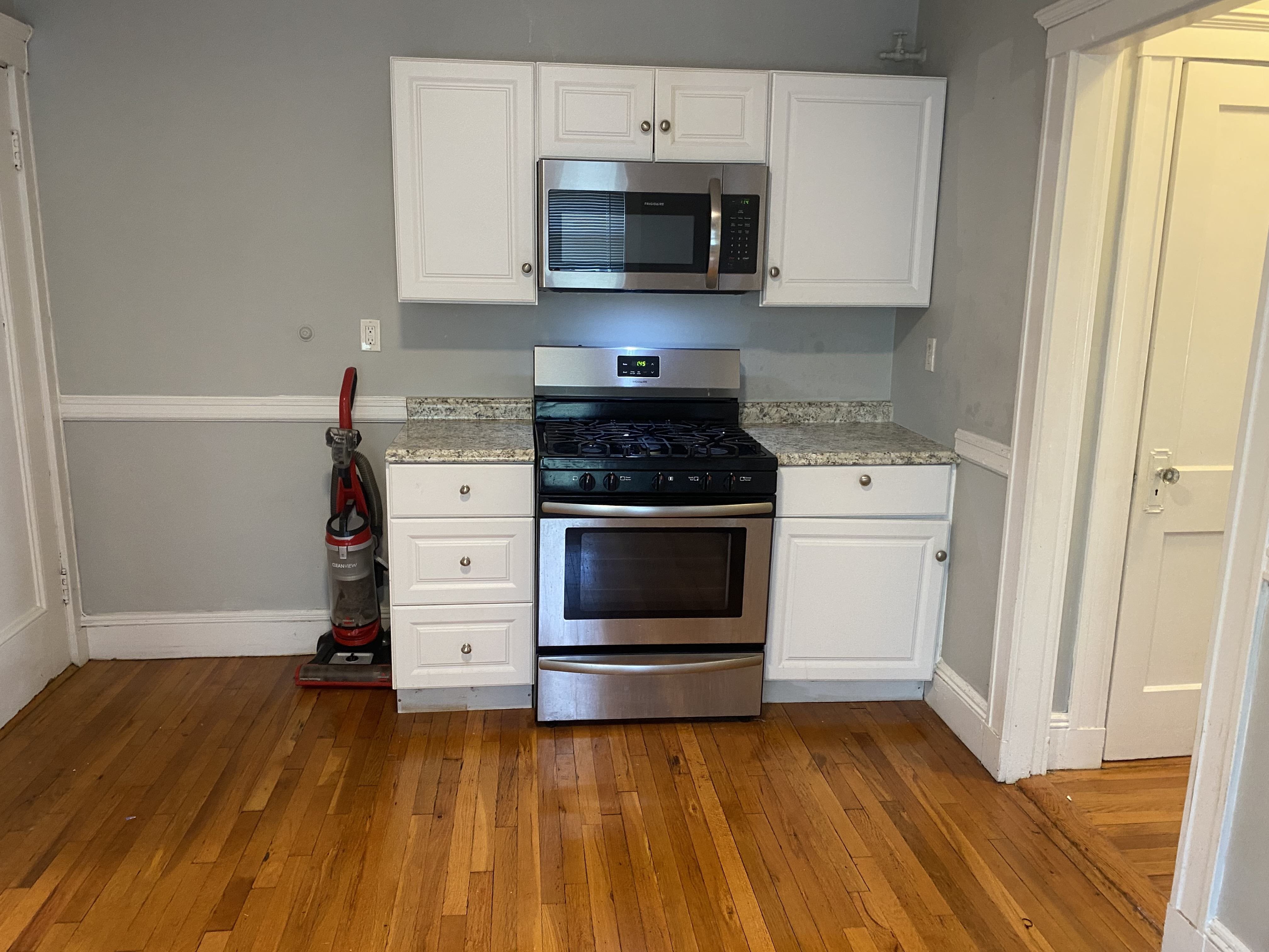 A kitchen with a stove, oven, and cabinets.