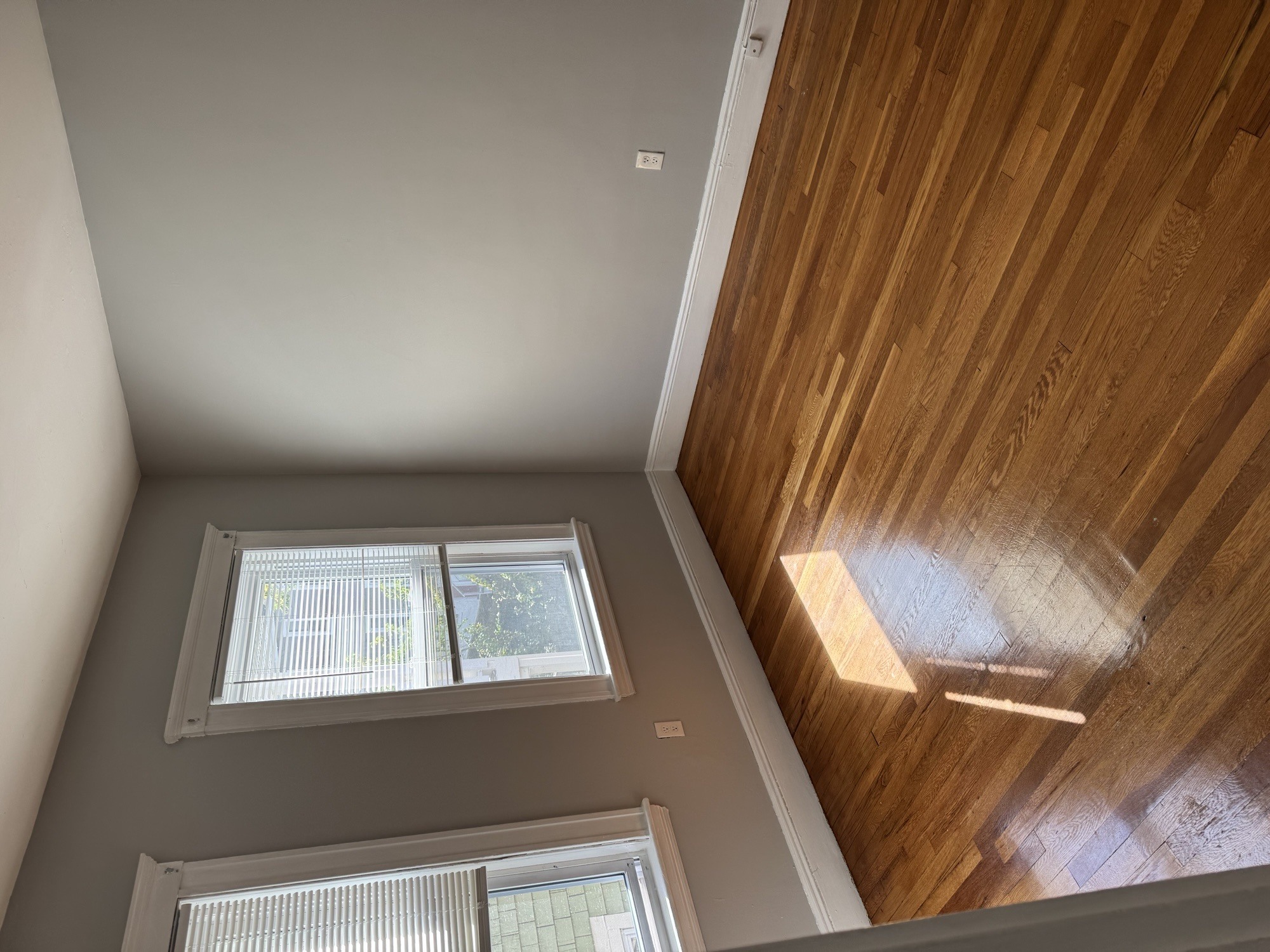 A view of a room with a window and wooden ceiling.,A view of a room with a window and wooden ceiling.