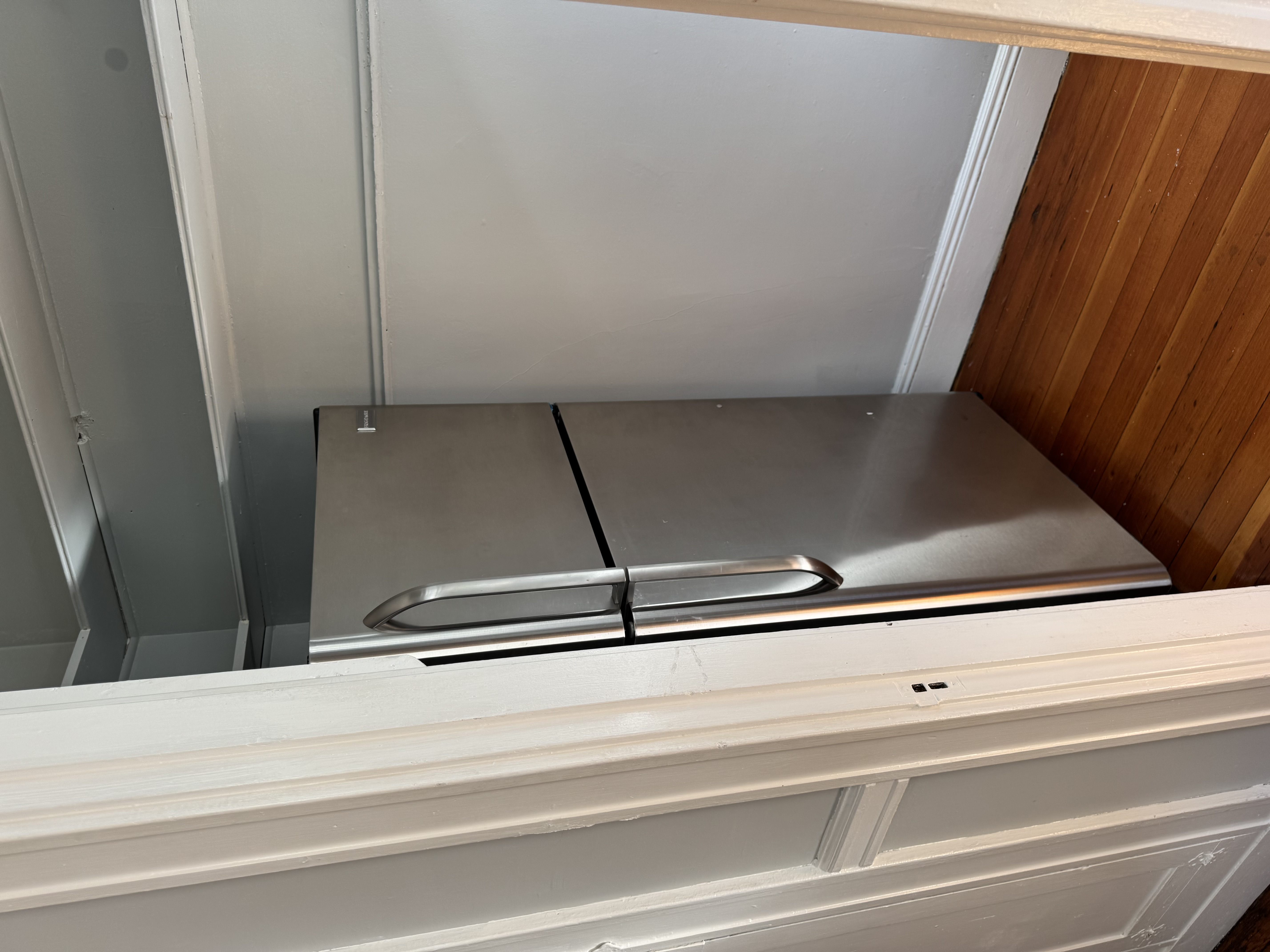 A stainless steel refrigerator with a freezer drawer and a handle on the top.