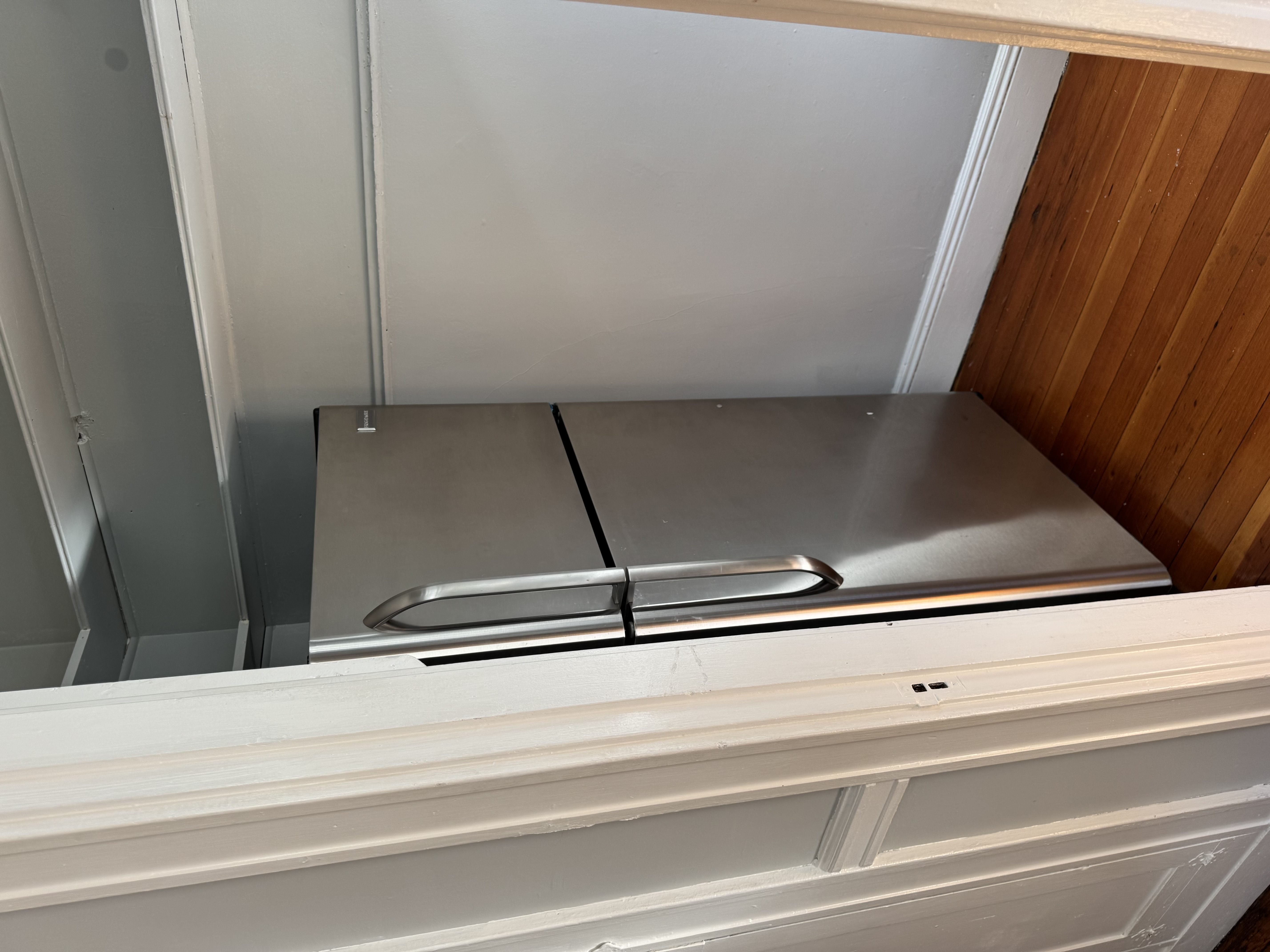 A stainless steel refrigerator with a freezer drawer and a handle on the top.