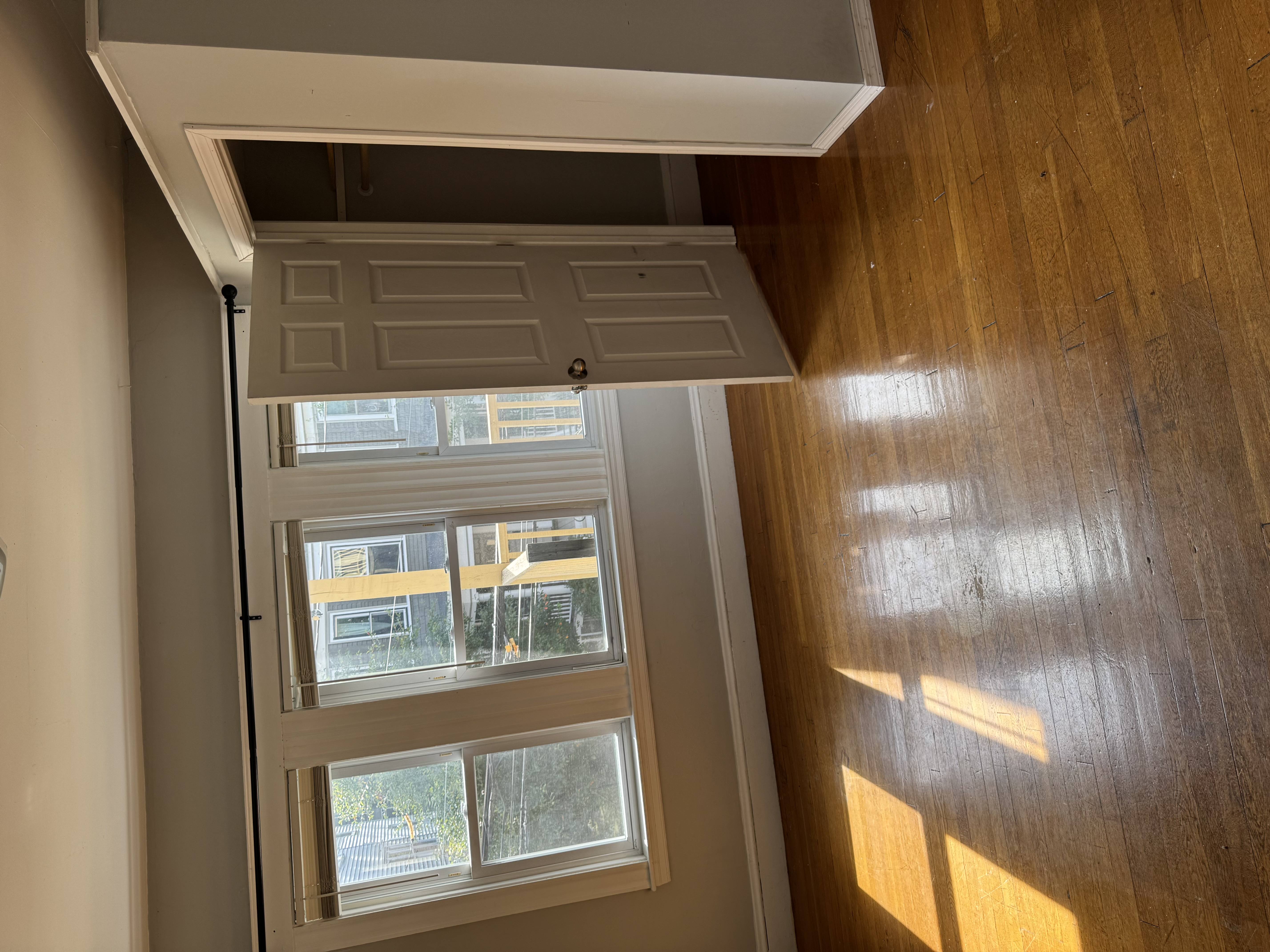 A white door with a window is open.