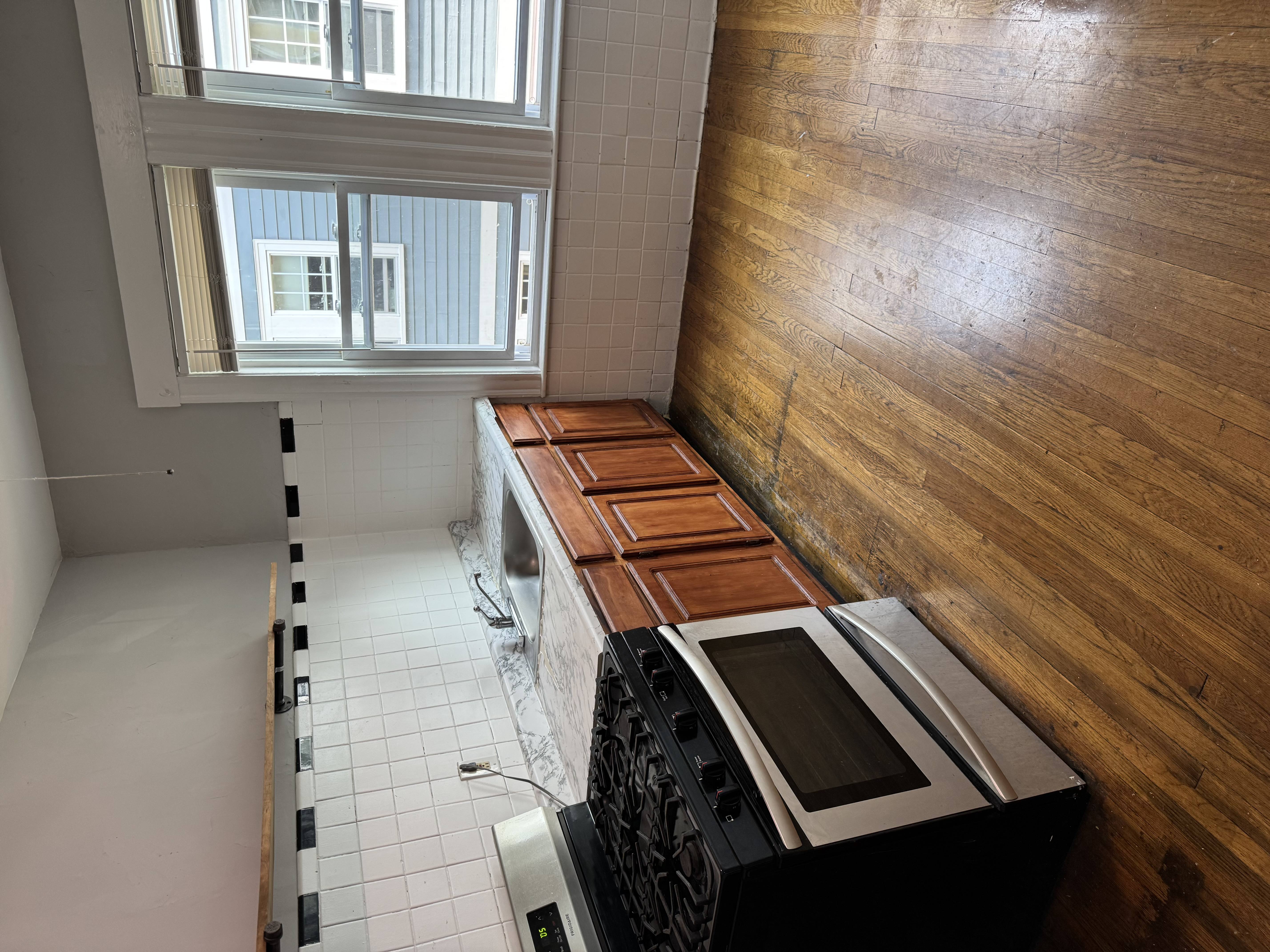 A kitchen with a stove top oven and a window.