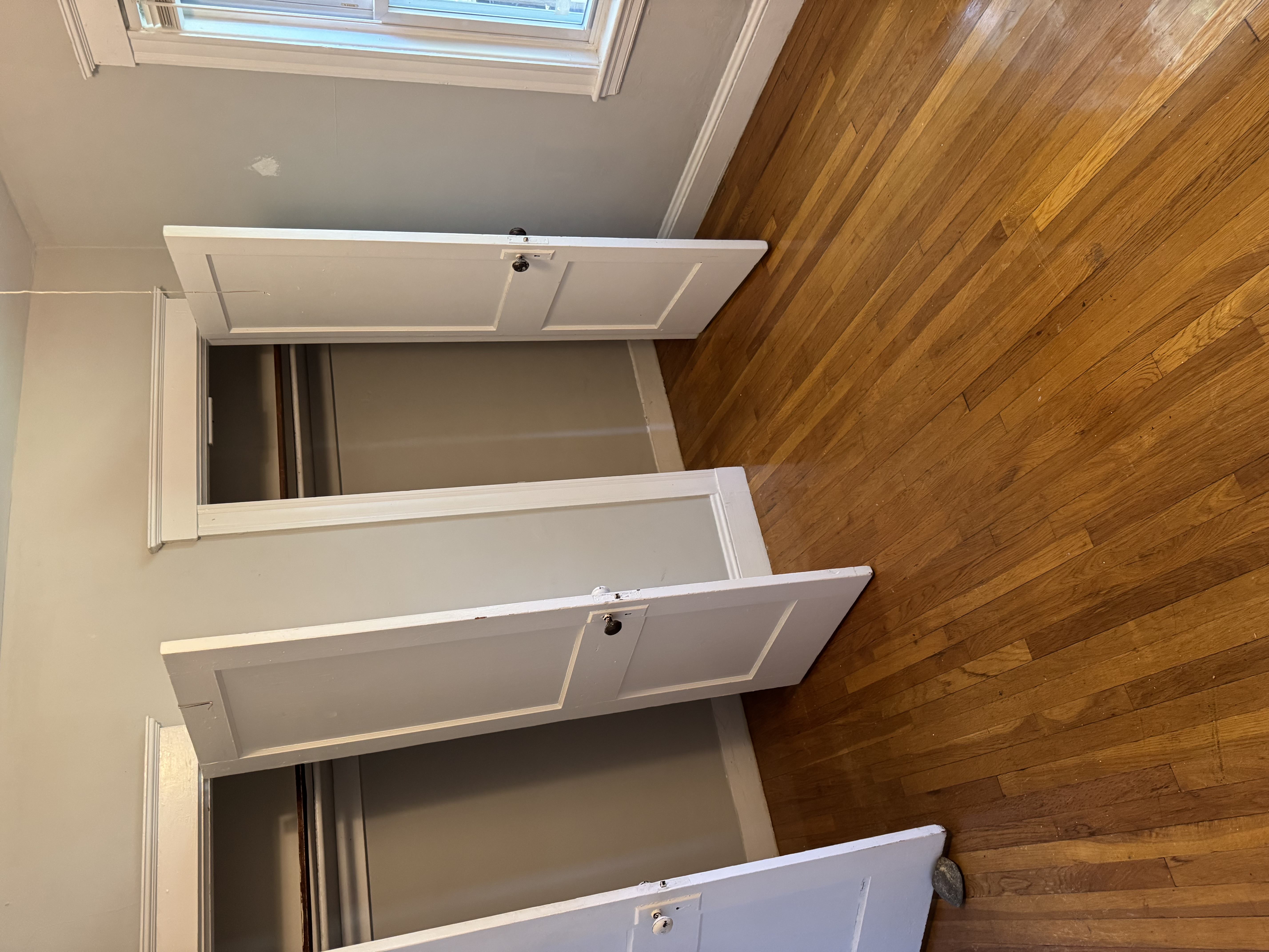 A wooden staircase with a white railing and a skylight above.