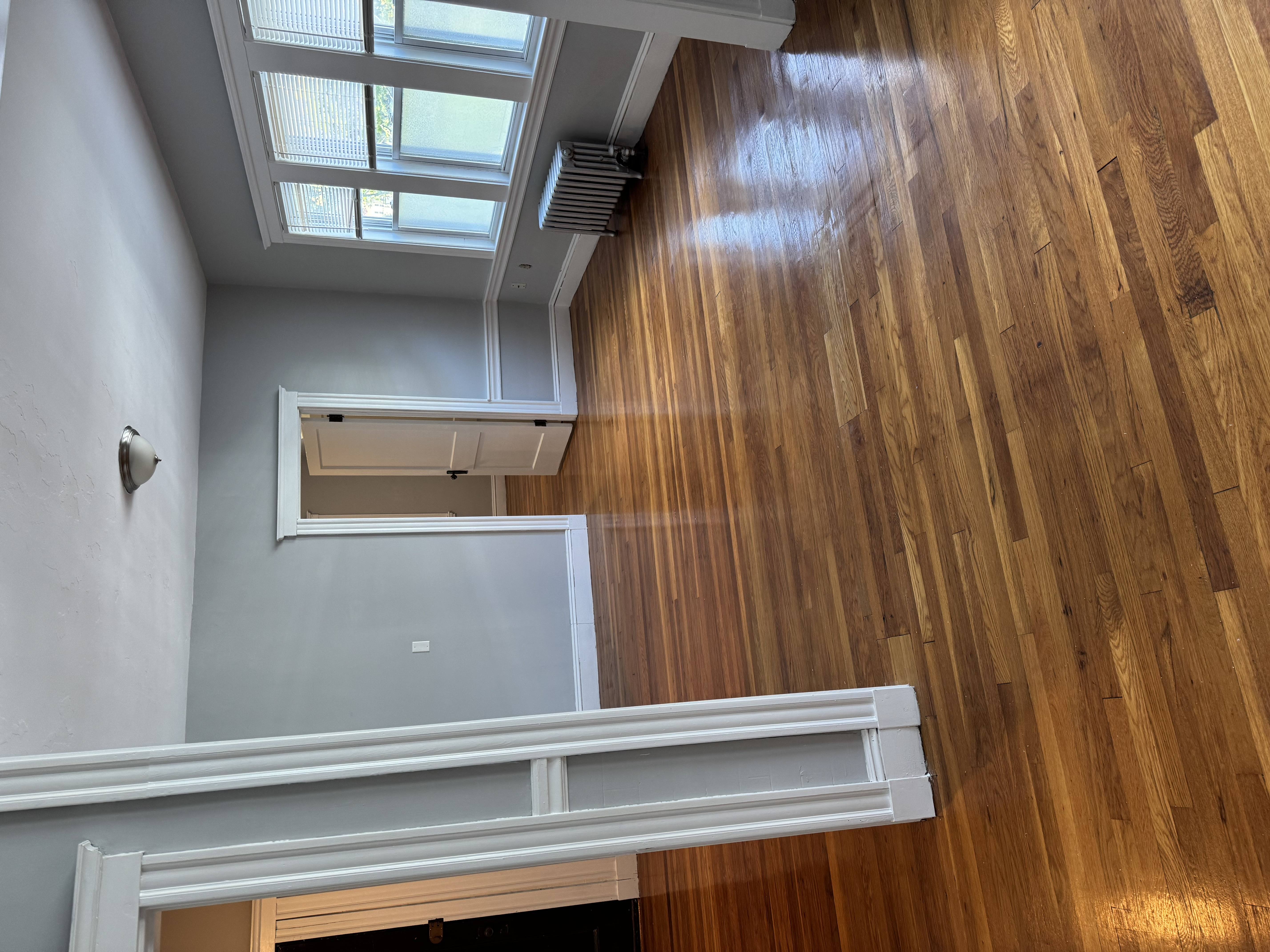 A wooden floor with a skylight above it.