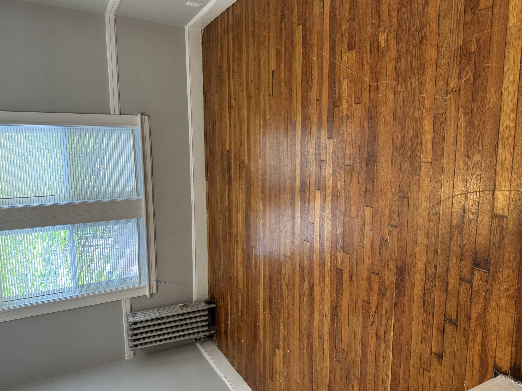 A room with a window and a wooden wall.