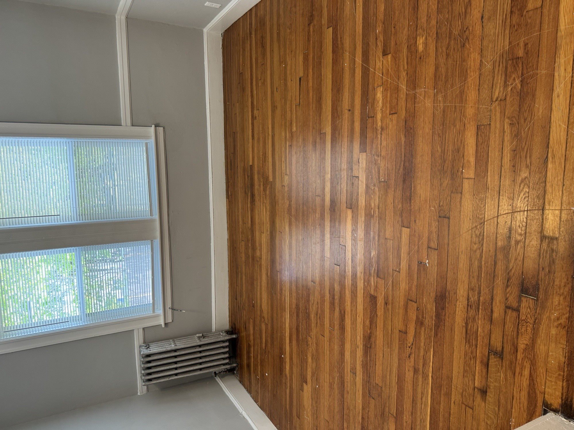 A room with a window and a wooden wall.