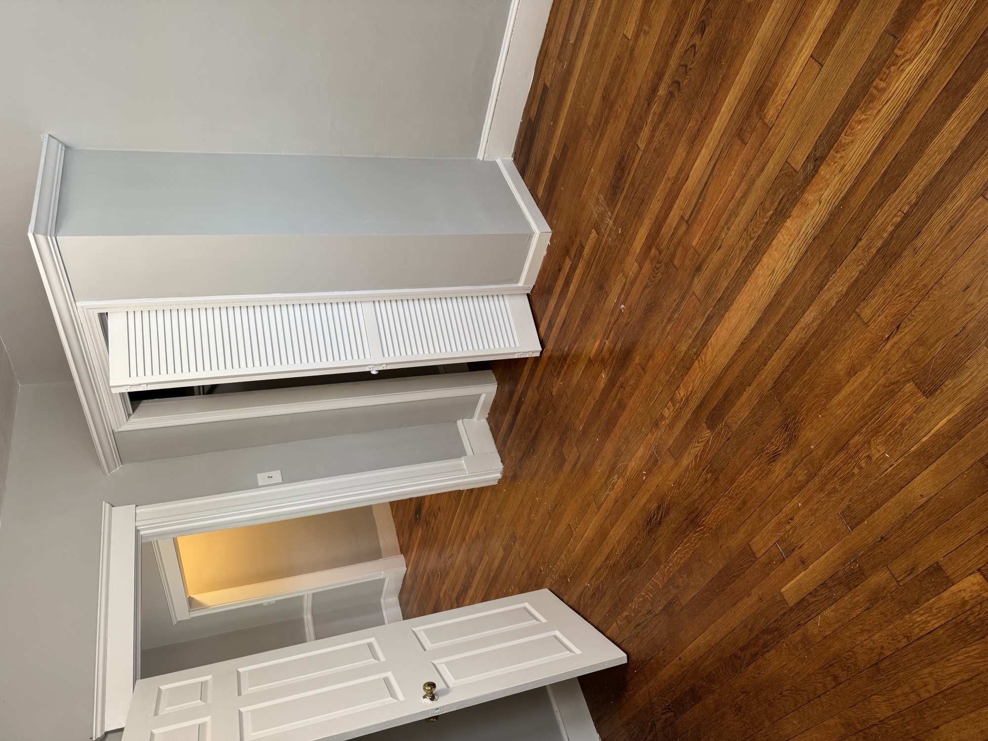 A white ventilation hood is installed in a room with wooden walls.
