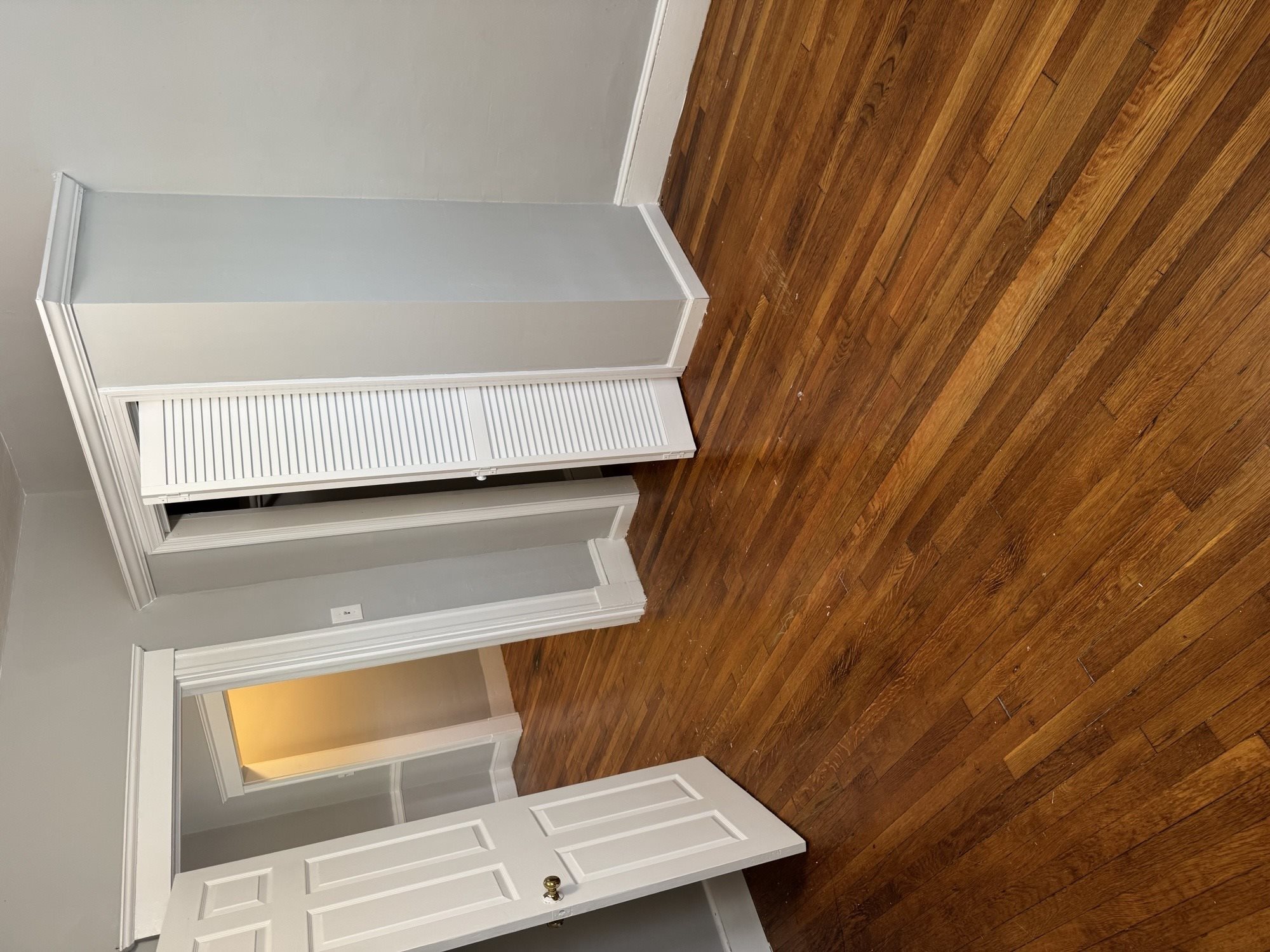 A white ventilation hood is installed in a room with wooden walls.