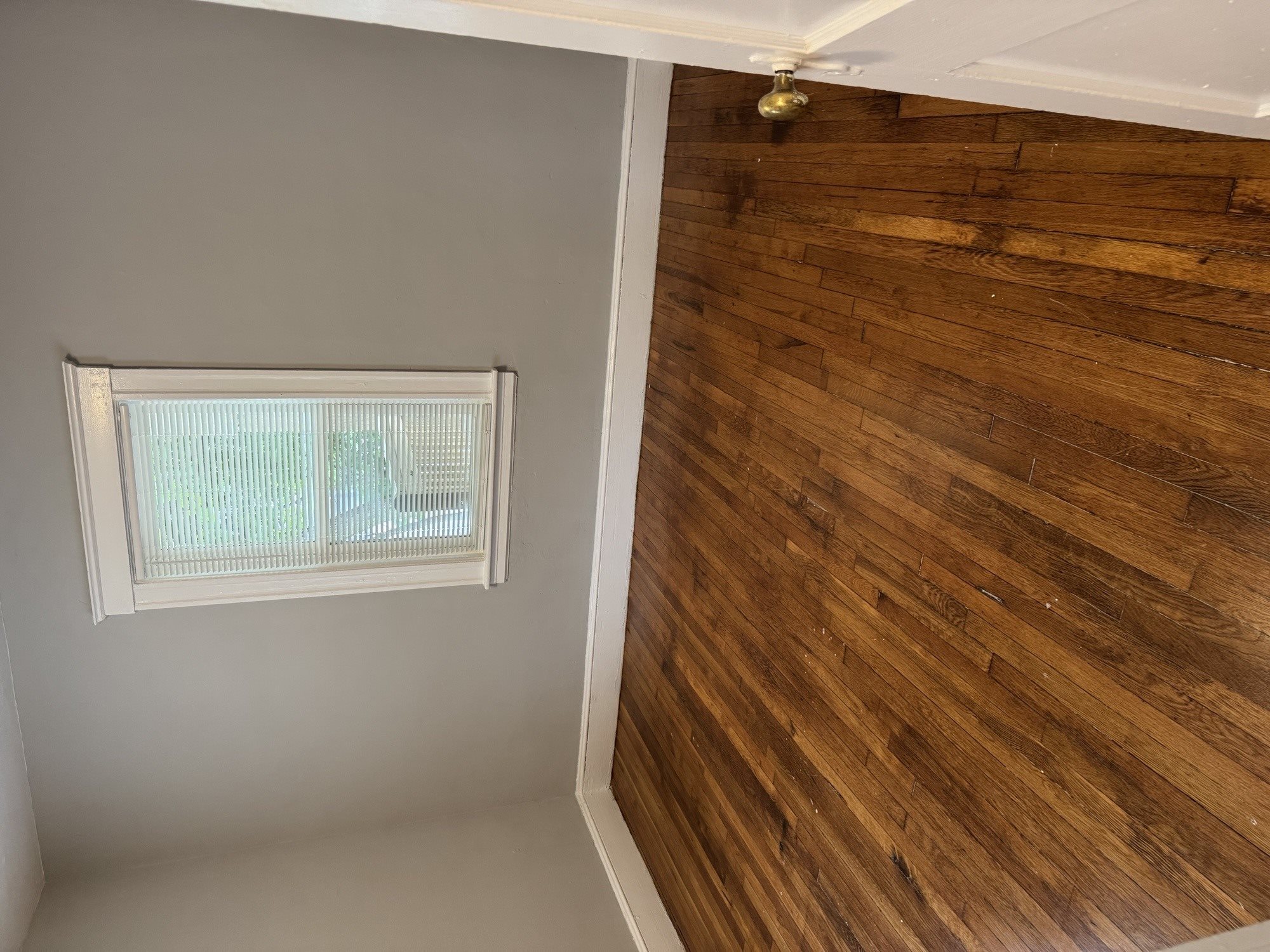 A room with a window and a wooden wall.,A room with a window and a wooden wall.