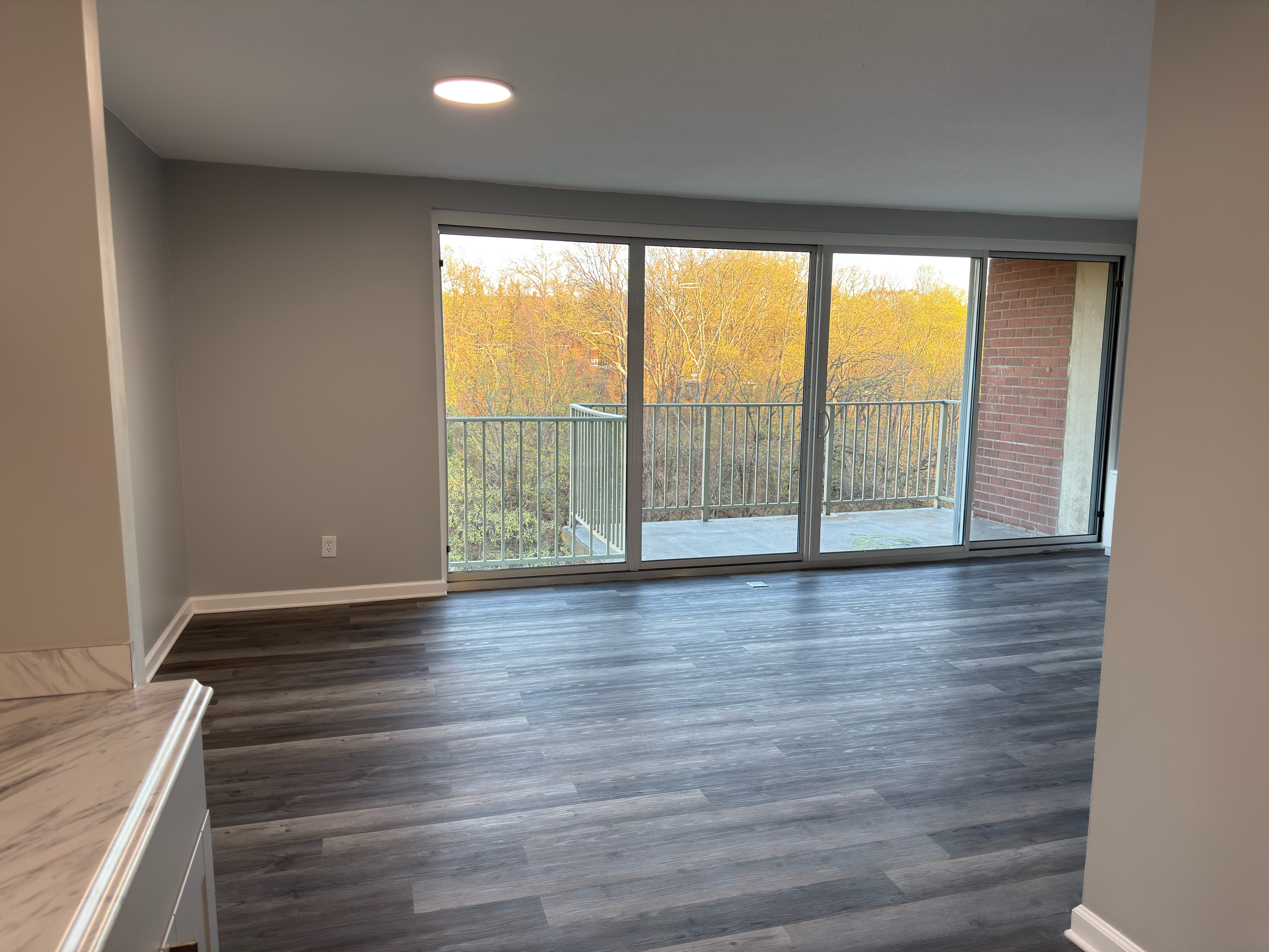 A room with a sliding glass door leading to a balcony.