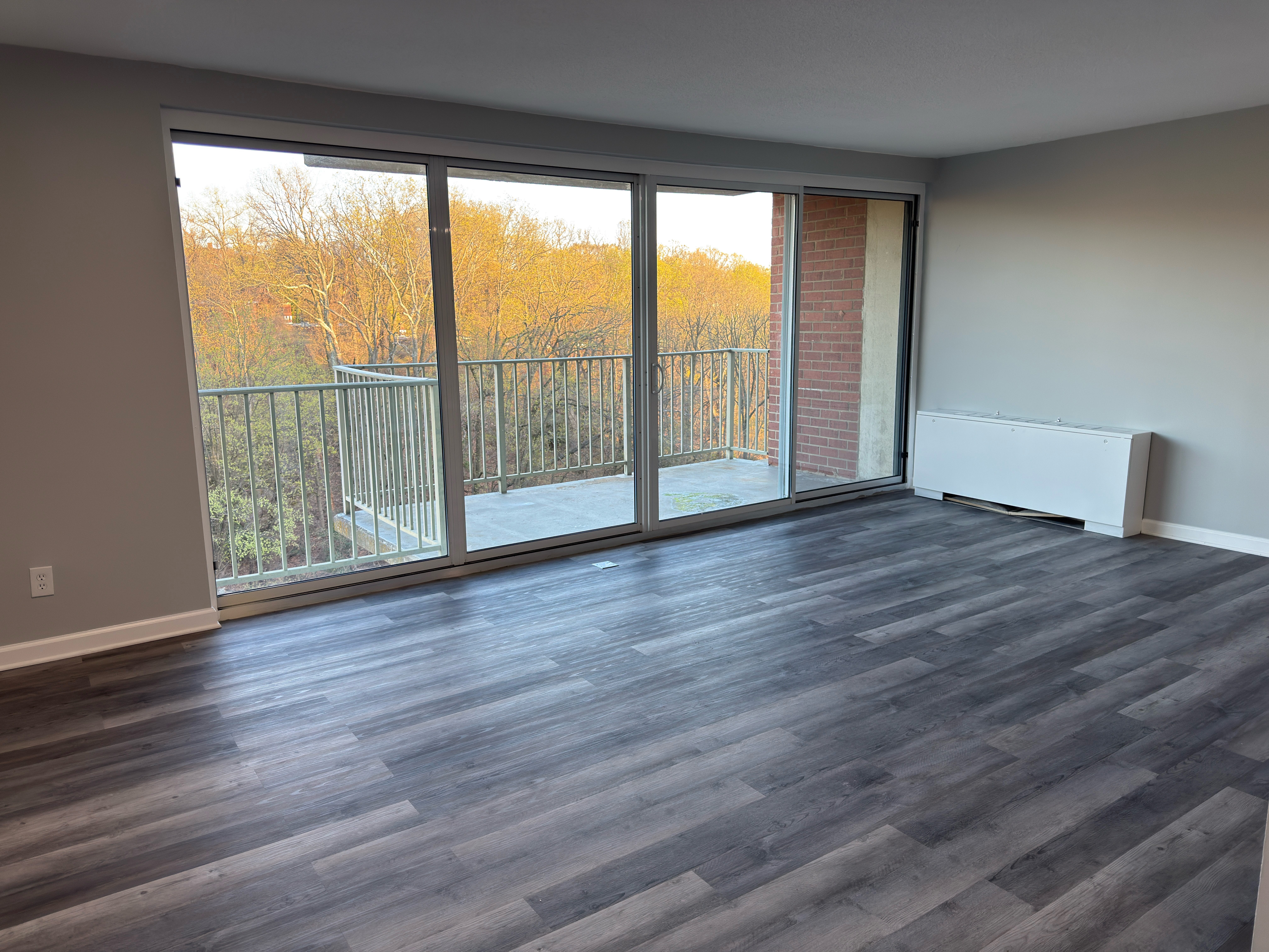 A room with a large window and sliding glass doors.