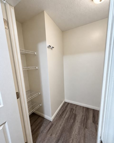 A small white closet with a door and shelves.