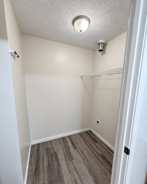 A small, empty room with a closet and a light on the ceiling.