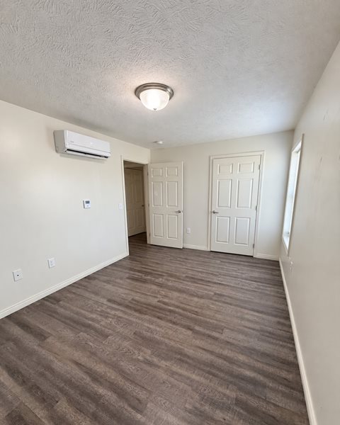 A room with a carpeted floor and a ceiling fan.
