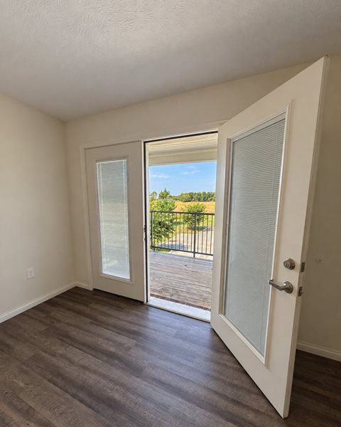 A room with a sliding glass door leading to a balcony.
