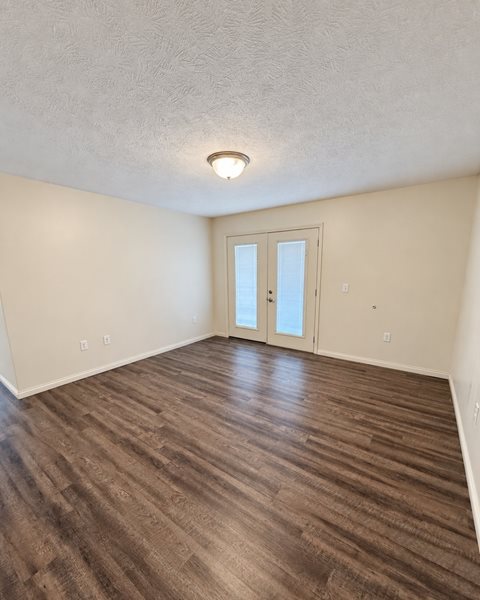 A room with a wooden floor and a white door.