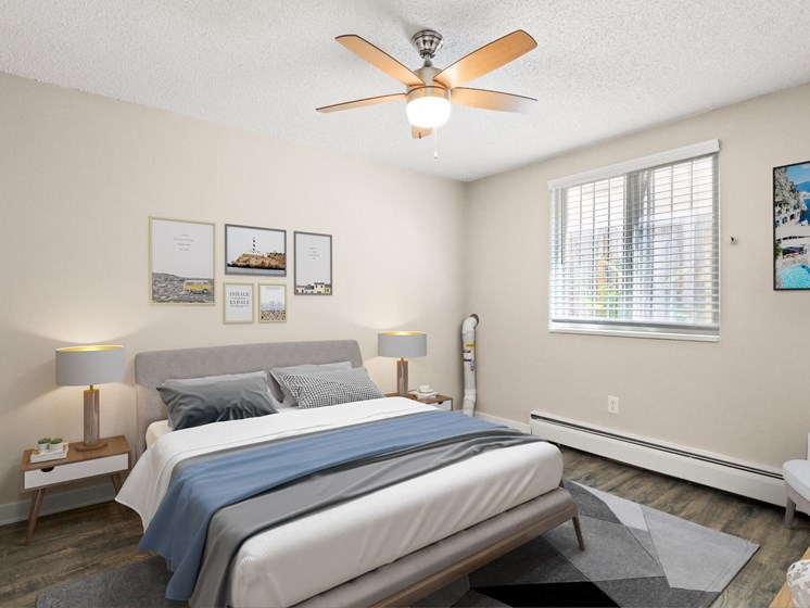 Bright bedroom with large window, ceiling fan, queen bed, and modern decor on light walls at 1443 Elizabeth in Denver, CO