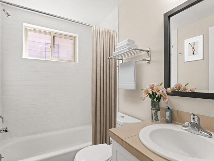 Modern bathroom with a white tile shower, built-in tub, single vanity, and neutral-toned finishes at 1443 Elizabeth in Denver, CO