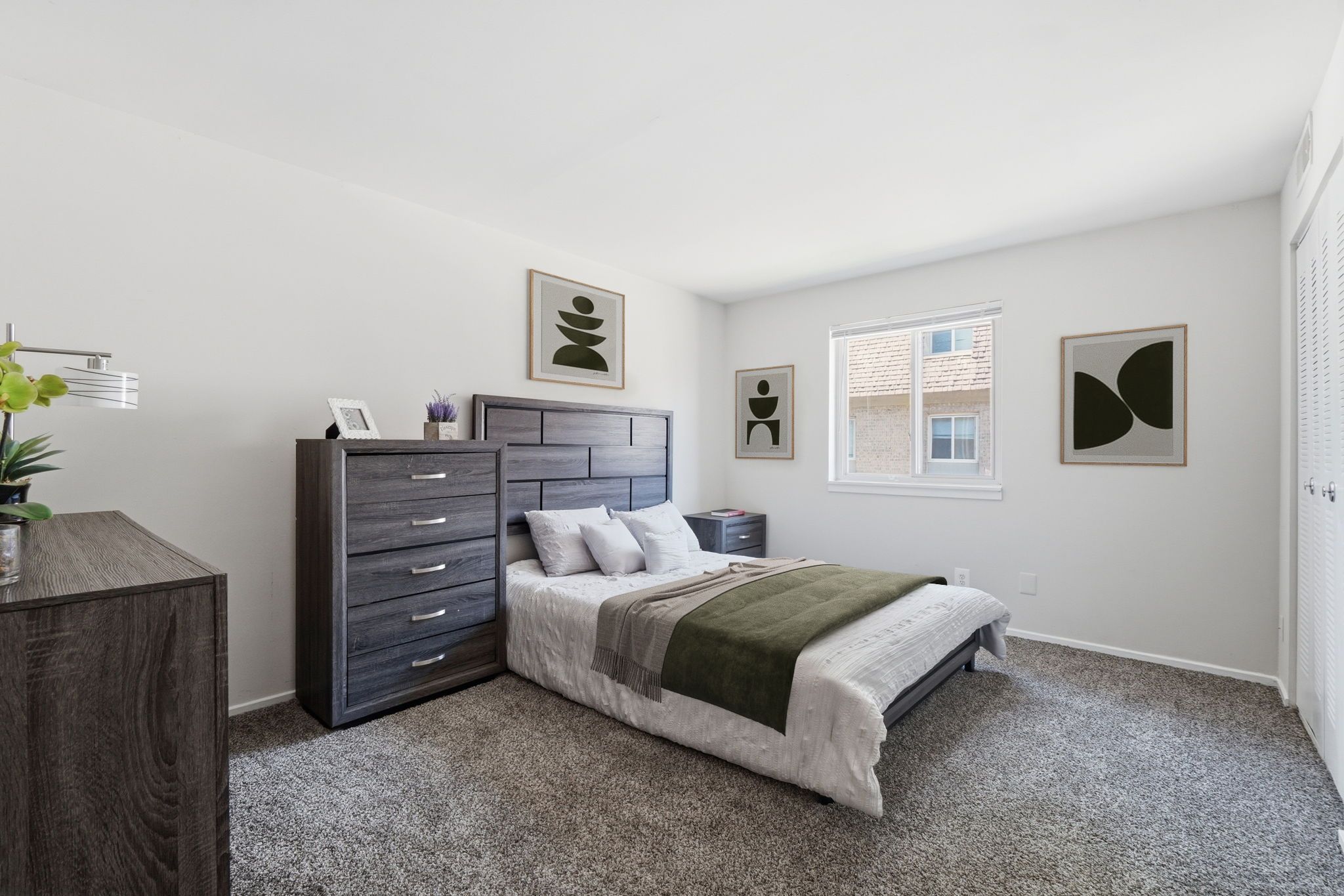 A bedroom with a bed, dresser, and nightstand.