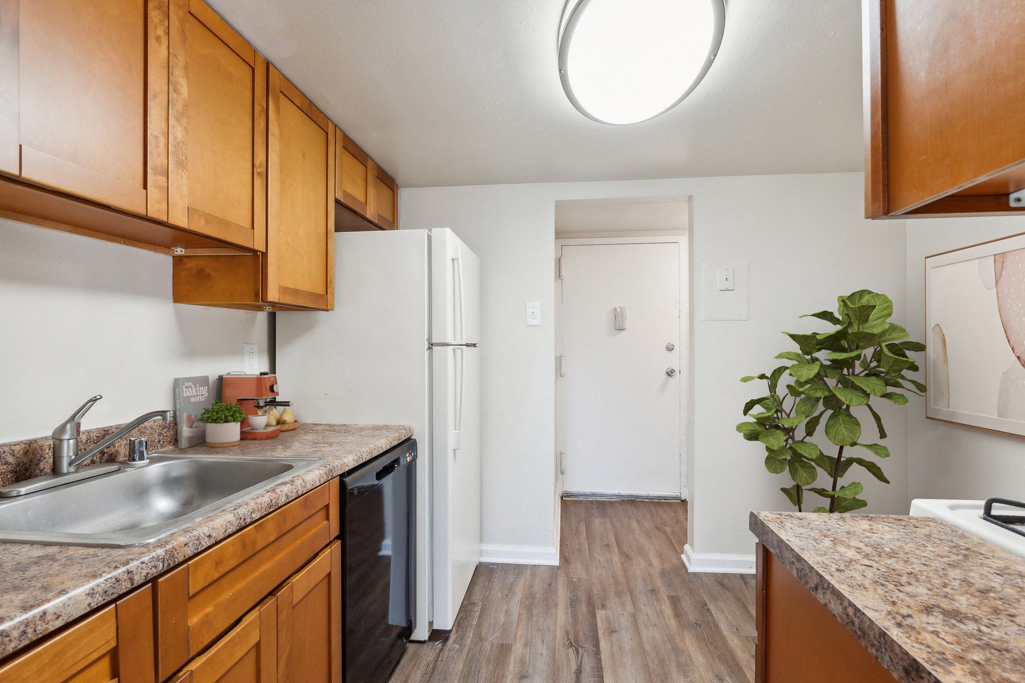 a kitchen with wooden cabinets and a sink and a refrigerator