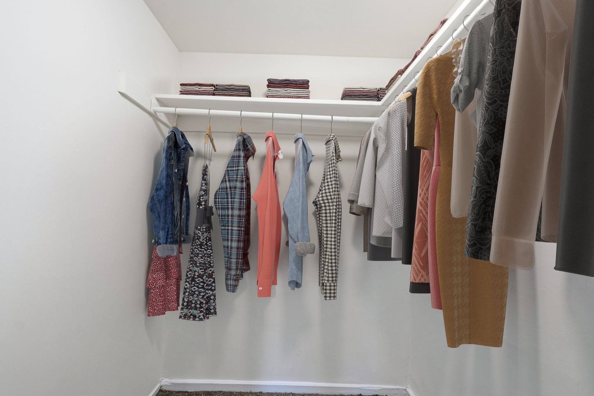 Clothes hanging on a white shelf.