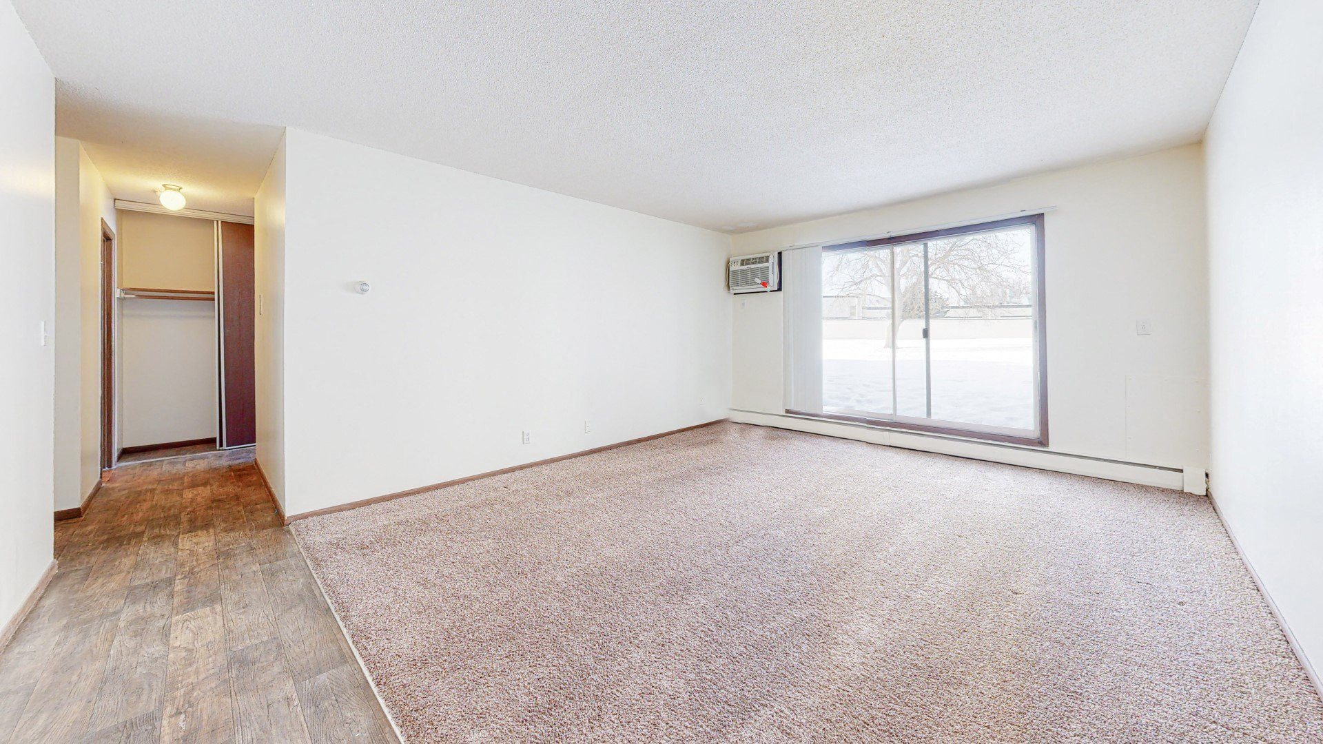 a bedroom with a large window and white walls