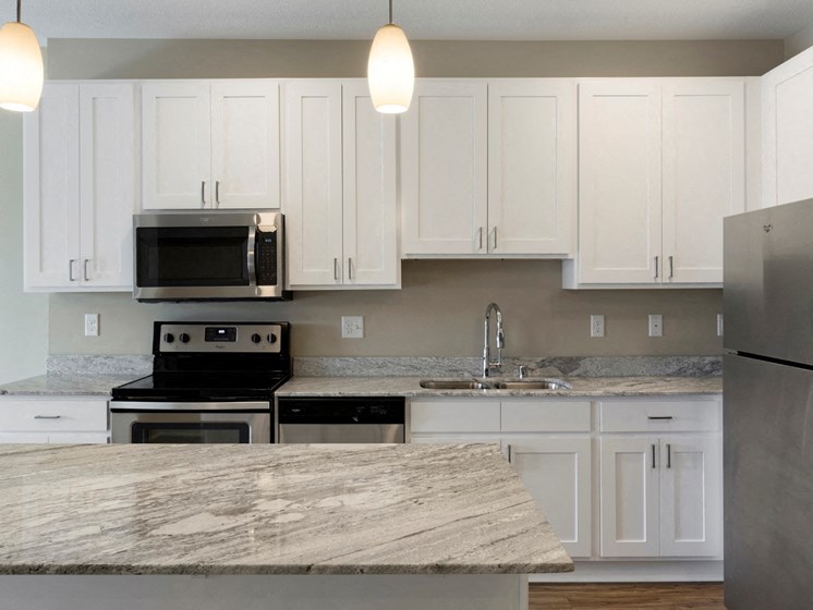 Kitchen with white cupboards and island at The Liberty Apartments in Golden Valley, MN