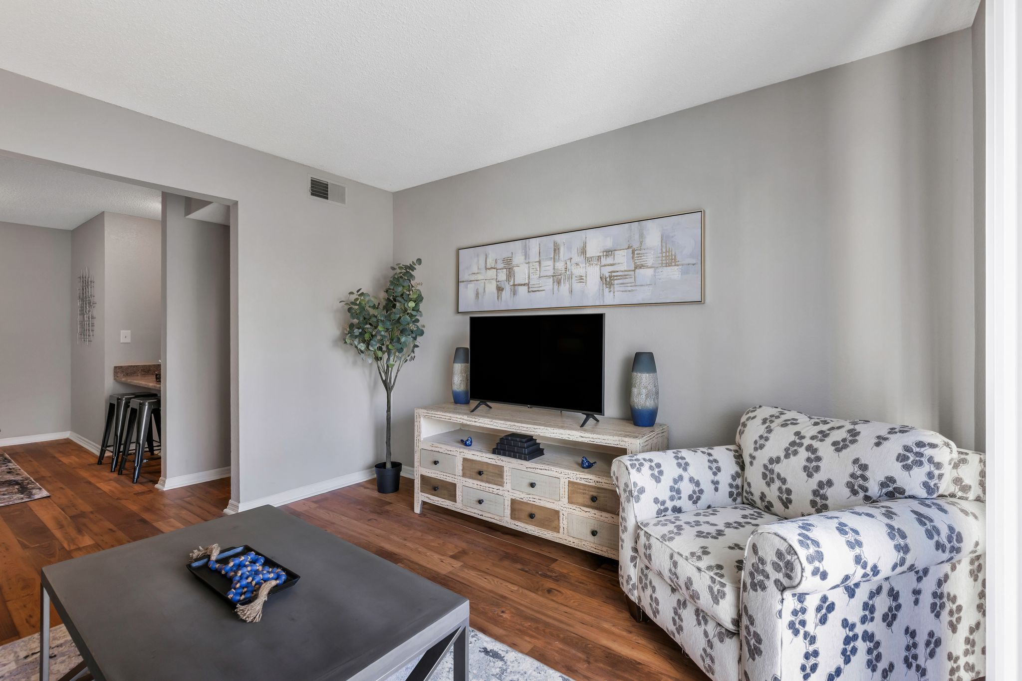 A living room with a grey couch and a black coffee table.