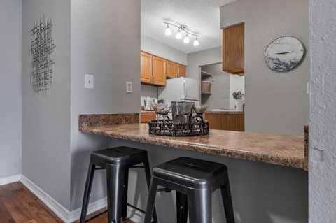 A kitchen with a bar area and two stools.